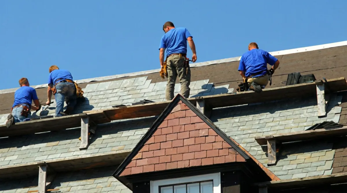 Roof replacement in progress with a team of professional contractors installing new shingles on a residential home in Wilmington, NC